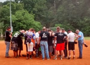 At the end of the Shane Moore Benefit Softball Tournament, players knelt down on the field and prayed for Shane Moore. 